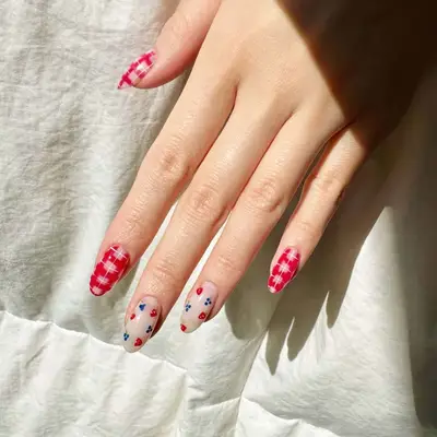 A hand with decorated fingernails featuring a patterned design