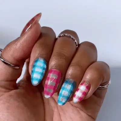 Close-up of a hand with nail art featuring polka dots and two rings on the fingers