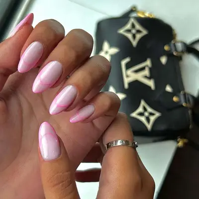 negative space manicure with base in shiny light pink with hot pink french negative space tips