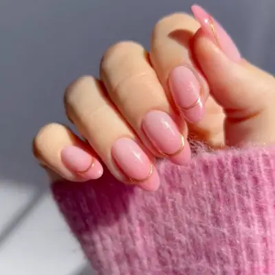 negative space French manicure with base in light pink with gold french trim