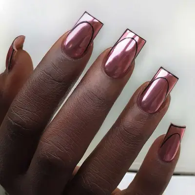 negative space manicure with rose gold chrome base and black negative space french tips
