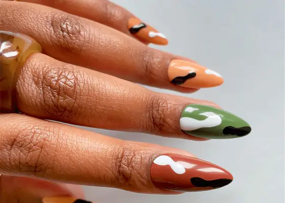 Minimalist camo nails with green, brown, and tan bases