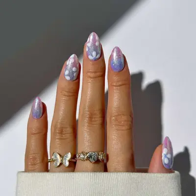 Manicure with pink and purple shimmer base and daisy designs