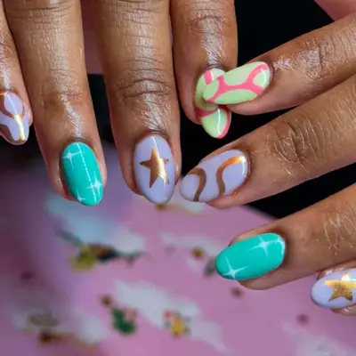 Manicure with mismatched pastel swirl, sparkle, star, and squiggle designs