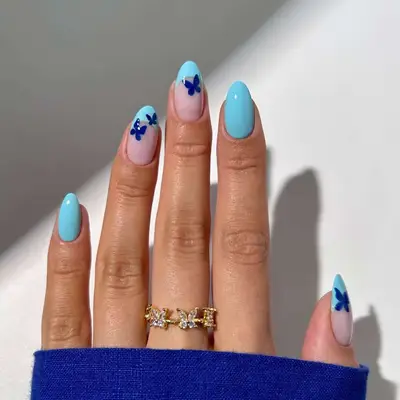 Blue manicure with French tips and butterfly designs
