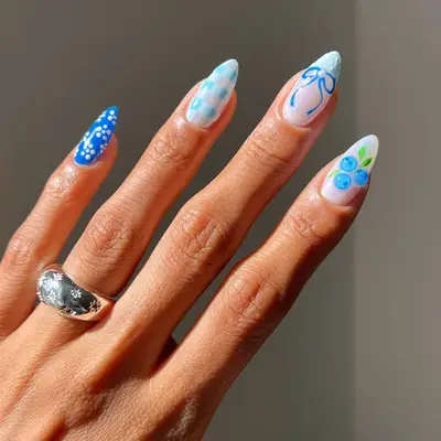 Manicure with blue floral, plaid, bow, and blueberry designs