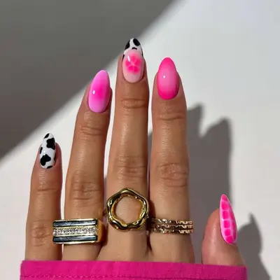 Manicure with pink aura nails, florals, and cow print nails, and pink croc nail 