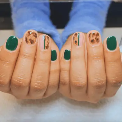 Short, rounded acrylic nails with green and leopard mismatch pattern
