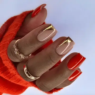 Short, square-shaped acrylic nails with mismatched red and gold design