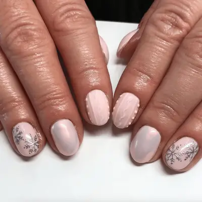 Short pink acrylic nails with winter motifs and sweater texture