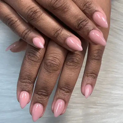 Short, pink acrylic nails with pointed tips