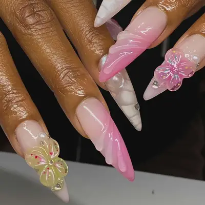 Decorated fingernails with floral designs and sculpted tips