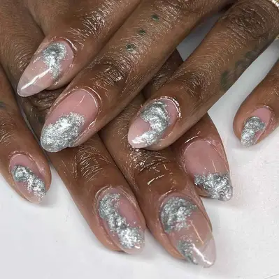 Close-up of hands showcasing nail art with a silver and nude design