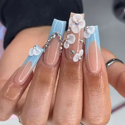 A hand displaying long sculpted nails adorned with decorative accents and floral designs