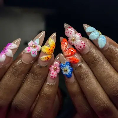 Decorative nails featuring intricate flower designs and bright colors, close-up view of a manicure showcase