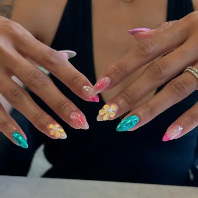 Hands displaying colorful nail art with floral designs