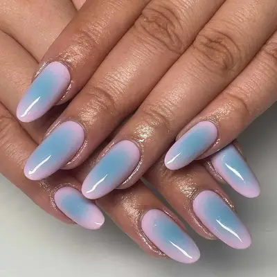 Close-up of hands featuring well-manicured nails with a gradient design