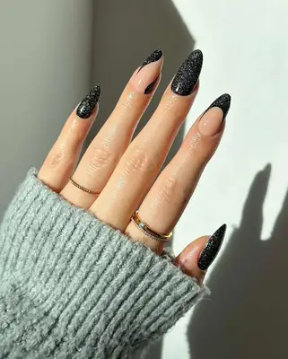 Close up of a hand with black glitter French mismatched manicure