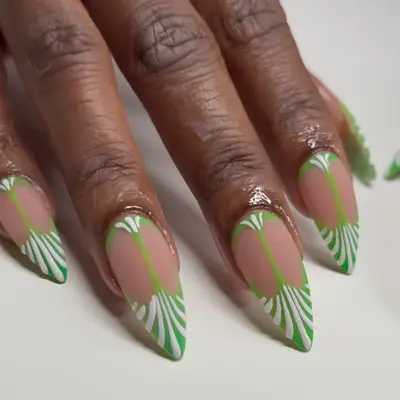 a green and white manicure with an art deco design