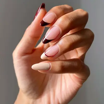 French manicure with cream, black cherry, and nude colors.