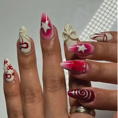 Black cherry and cream manicure with bows and star decals.