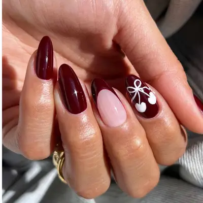 Black cherry nails with bow-cherry detail in white.