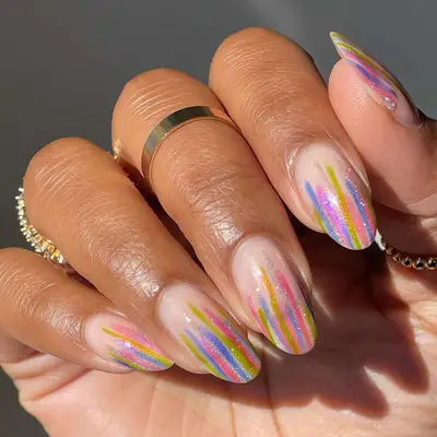 Bubble bath pink manicure with blue, green, and pink sparkly stripes down the nail.