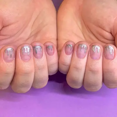 short round nails with a silver metallic melting design