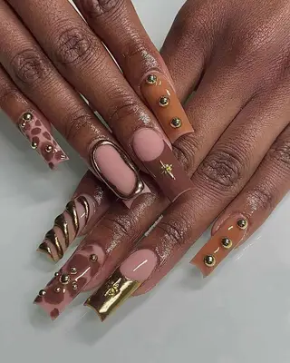 brown and gold chrome nails with embellishments