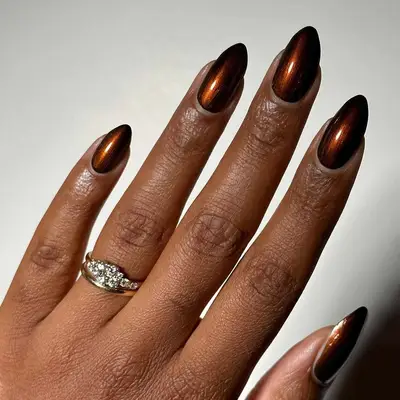 deep mahogany brown chrome nail polish on almond shaped nails