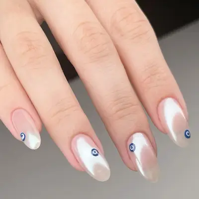 cotton candy nails with evil eye detailing on almond shaped nails
