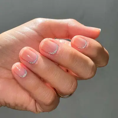 Manicure with clear base and silver glitter cuticle rim