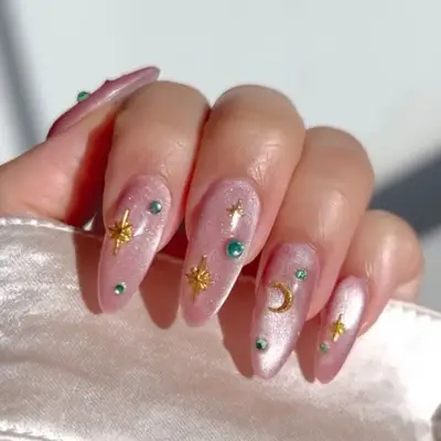 Hand showcasing celestial-themed manicured nails with decorative accents