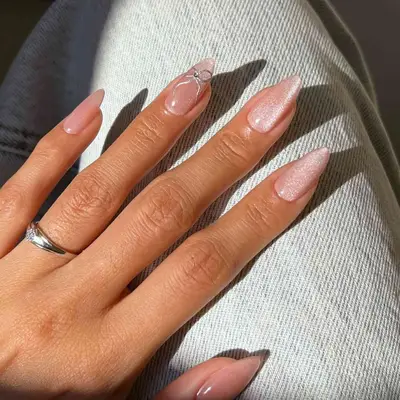 Close-up of manicured nails with a pink velvet finish and one finger sporting a design
