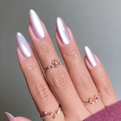 Hand with long nails, a glassy pink manicure, and floral rings