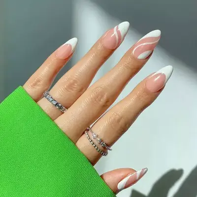 Almond-shaped nails with a swirling white design.
