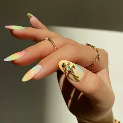pastel tie dye nails with a lizard charm