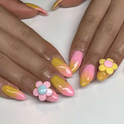 pink and yellow gradient nails with flower charms