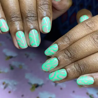Manicure with neutral base and wavy mint swirl design