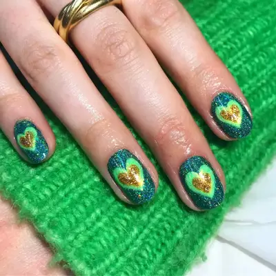 Manicure with green and gold glitter hearts