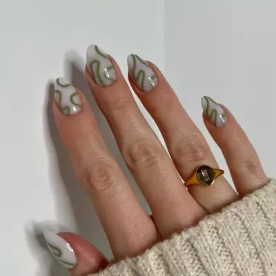 Manicure with milky white base and green squiggle design