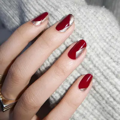 Short manicure with red base and abstract gold shimmer designs