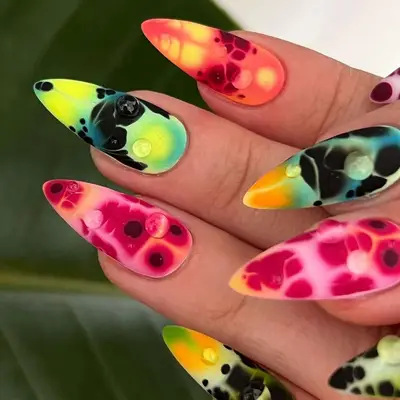 Close-up of hands with vibrant nail art featuring a deconstructed orchid pattern