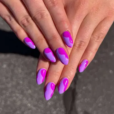 Hands showing nails with a purple and pink swirling nail art design
