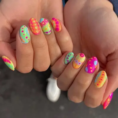 A close-up of hands with colorful, intricate nail art designs