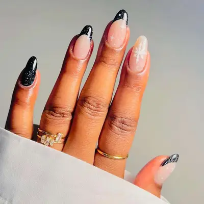 Manicure with black glitter nails and French tips and white snowflake designs