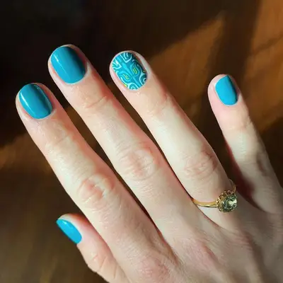 Teal manicure with abstract patterned accent nail