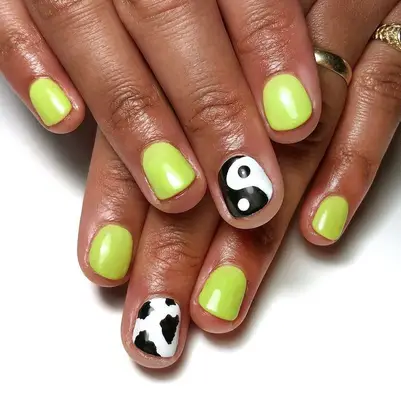 Lemon-lime manicure with black and white yin/yang and cow accent nails