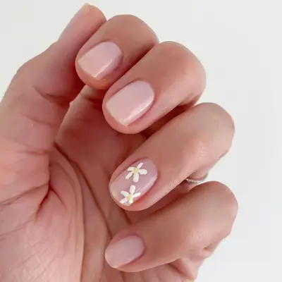 Simple neutral manicure with daisy floral accent nail