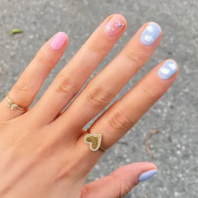 Cloudy sky manicure with butterfly accent nail